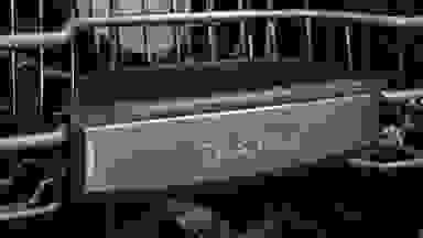 A close-up of the front of a Bosch dishwasher's top rack, which has the Bosch logo on it.